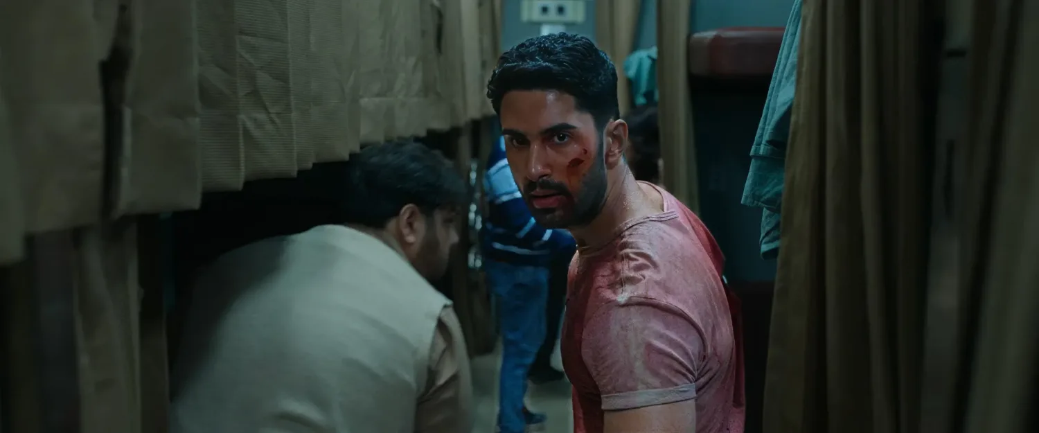 Lakshya as Amrit, bloodied and tense, crouches in a dim train corridor during a brutal fight scene in the Hindi action thriller Kill (2024).