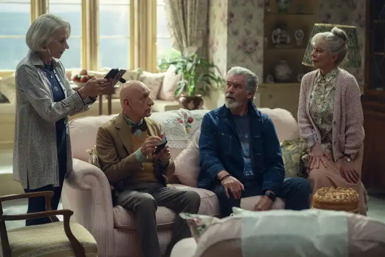 Helen Mirren, Ben Kingsley, Pierce Brosnan, and Celia Imrie sit together in a cozy living room as their characters from The Thursday Murder Club, discussing clues to a local murder.
