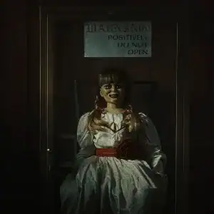 Annabelle doll locked inside a glass case with a warning sign reading “Positively Do Not Open” in The Conjuring: Last Rites review.